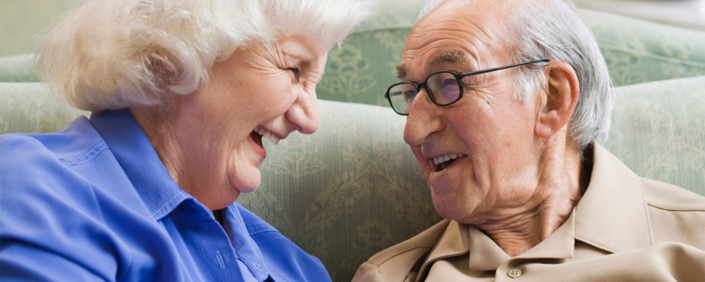 Pareja de personas mayores conversando y riendo